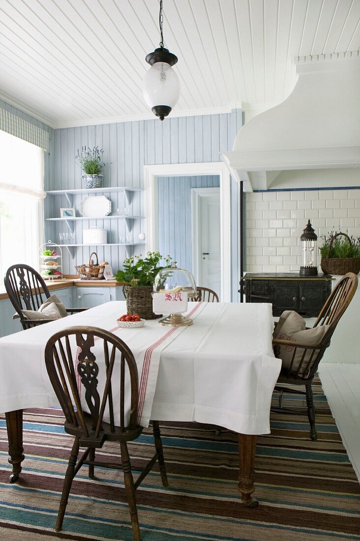 Potted strawberry and Windsor chairs in kitchen-dining room with wood-panelled walls