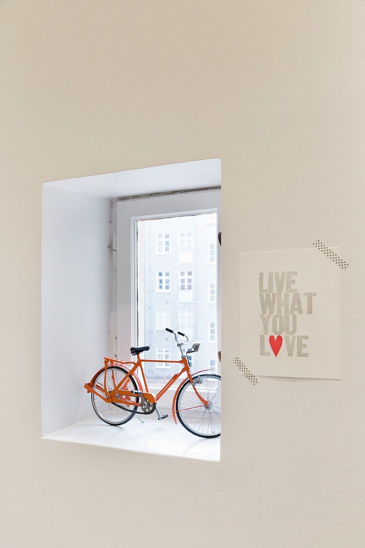Fahrrad-Modell in Fensternische, daneben Sinnspruch mit Masking Tape an die Wand geklebt