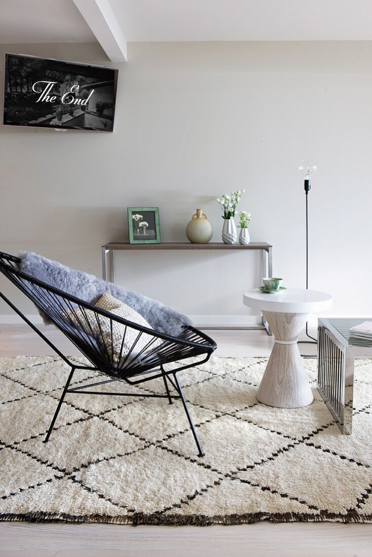 Retro Sessel mit schwarzer Seilverspannung und Beistelltisch in Weiß auf Berberteppich