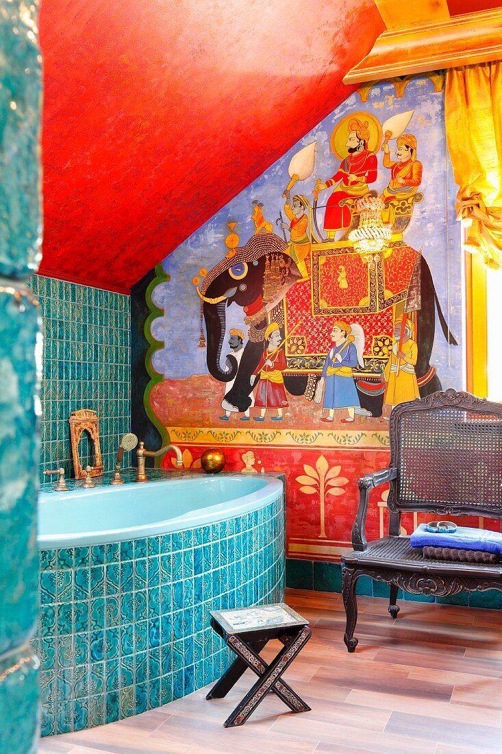 Indian-style decor in bathroom with elephant mahout motif, turquoise ornamental tiles on bath surround and wall
