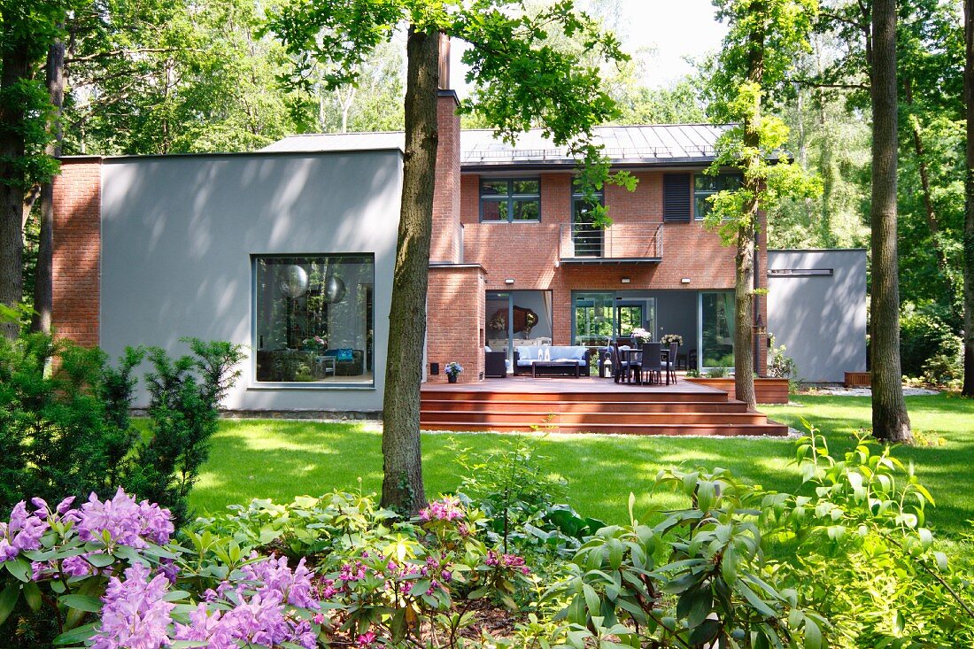 Modern house with brick facade, rendered elements, terrace & summer garden