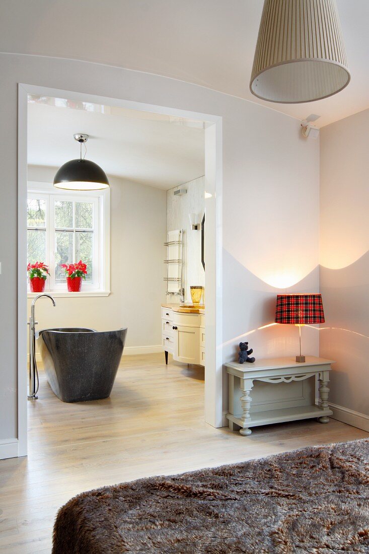 View of grey, free-standing bathtub through open bedroom doorway