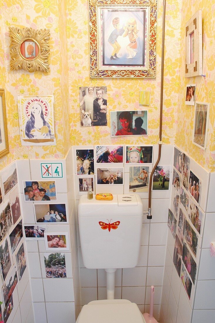 Foto- & Bildersammlung auf Fliesen und tapezierter Wand in Toilette