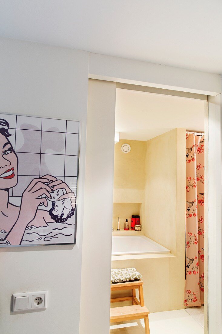 Bild in Pop Art an Wand im Vorraum neben offener Tür und Blick ins Bad