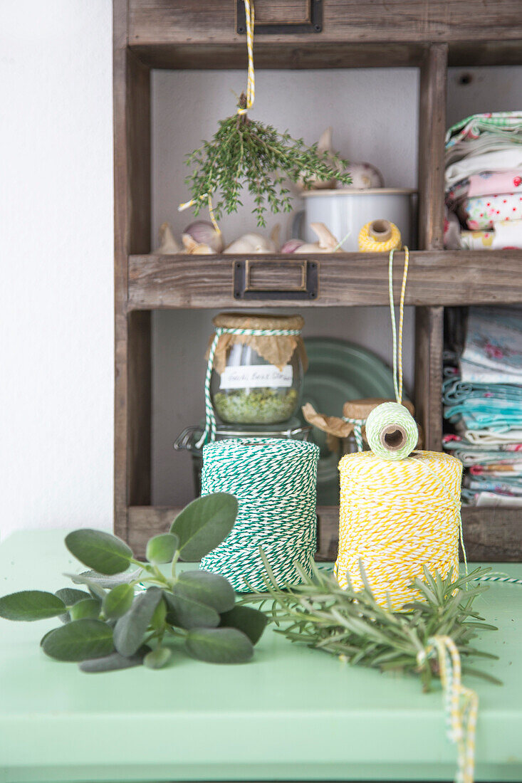 Bunches of herbs & roll of kitchen twine on dresser