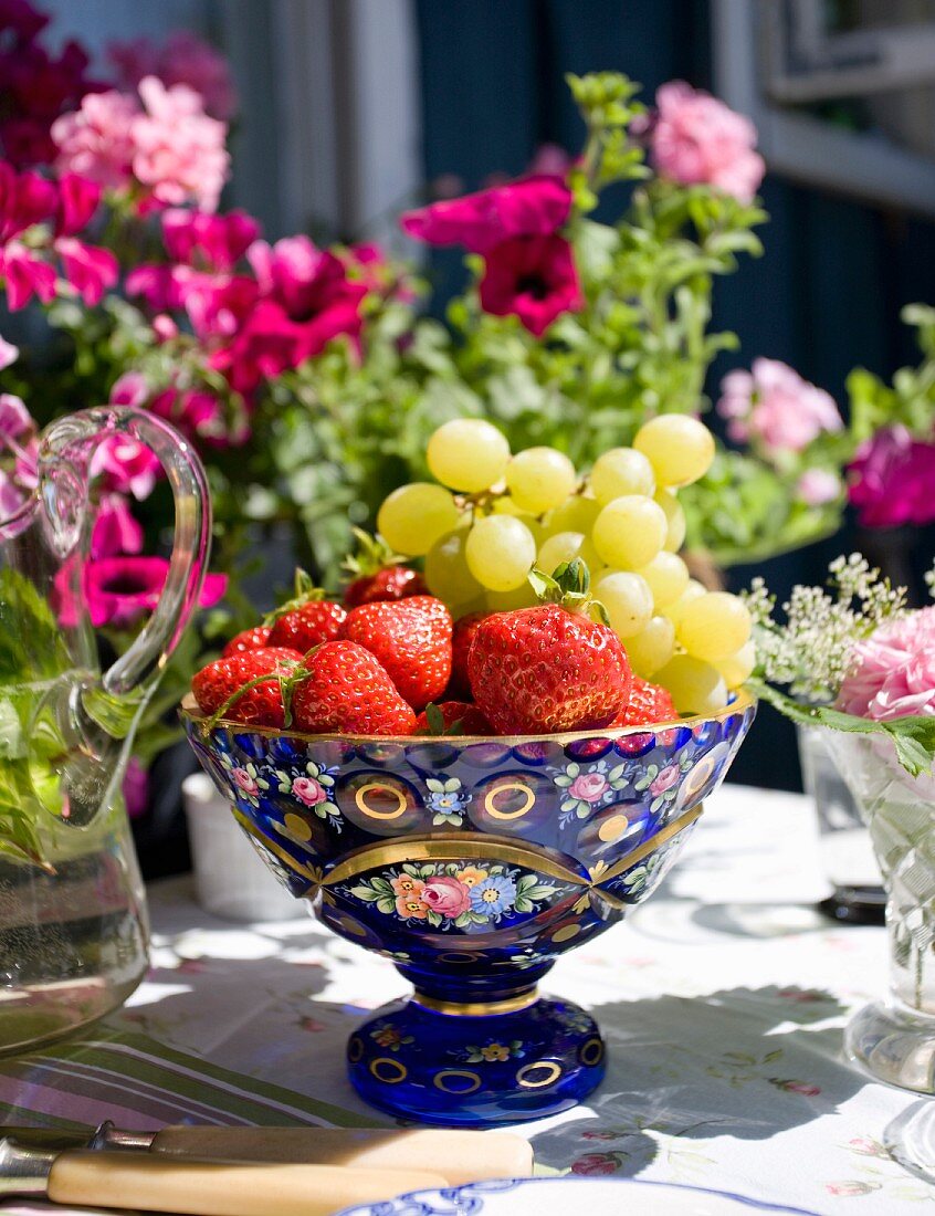 Frische Früchte in blauer nostalgischer Obstschale auf Gartentisch