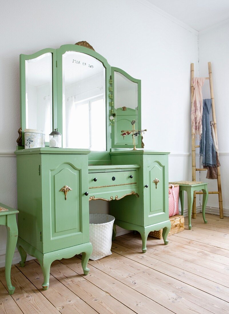 Green-painted, rustic dressing table with mirror and Vietnamese bamboo ladder on wooden floor