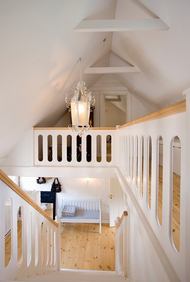 Staircase and landing in renovated attic; white-painted wooden staircase and wooden handrail