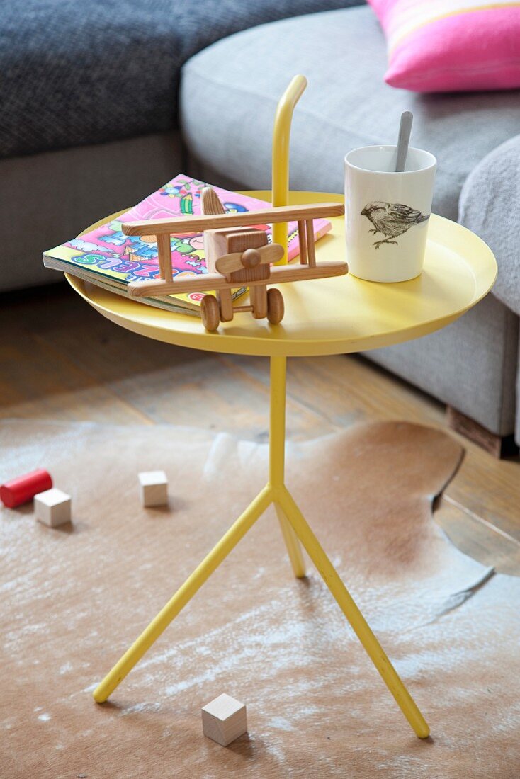 Wooden toys on yellow metal table on animal-skin rug