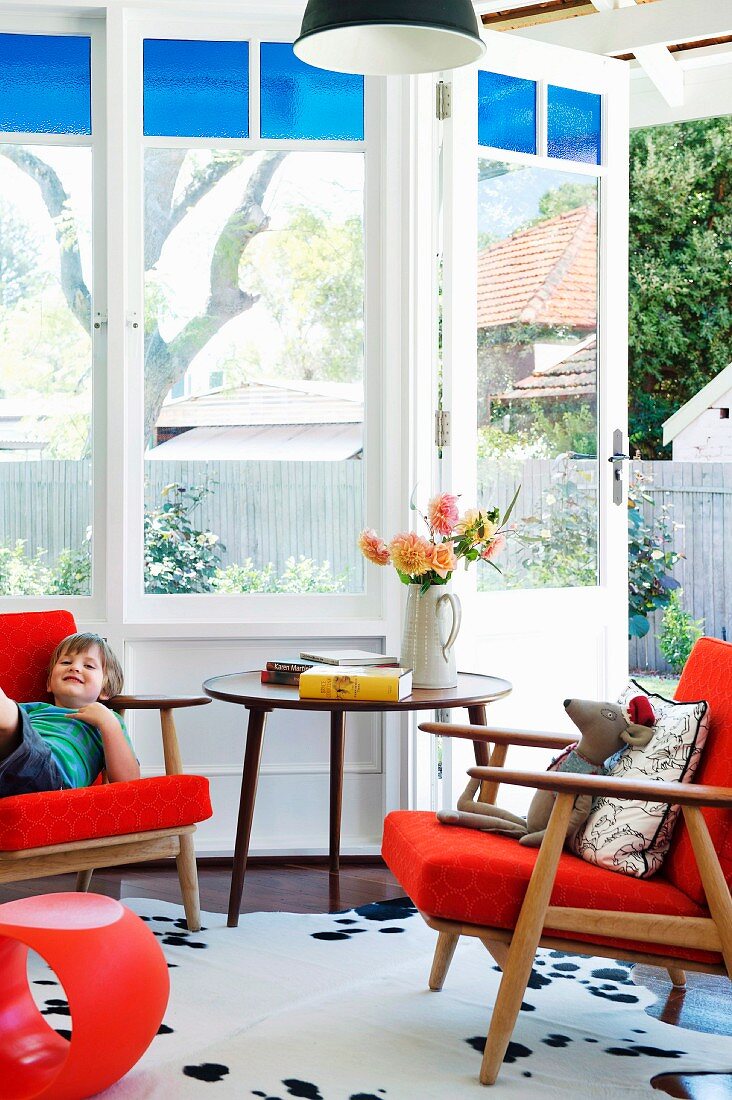 Classic retro furniture in orange in window bay with garden view