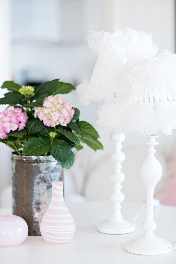 Weiße Tischleuchte mit DIY-Lampenschirm und Vase mit Hortensien