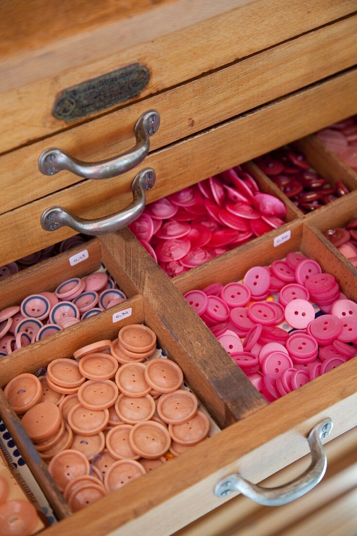 Colourful buttons in open drawer with dividers