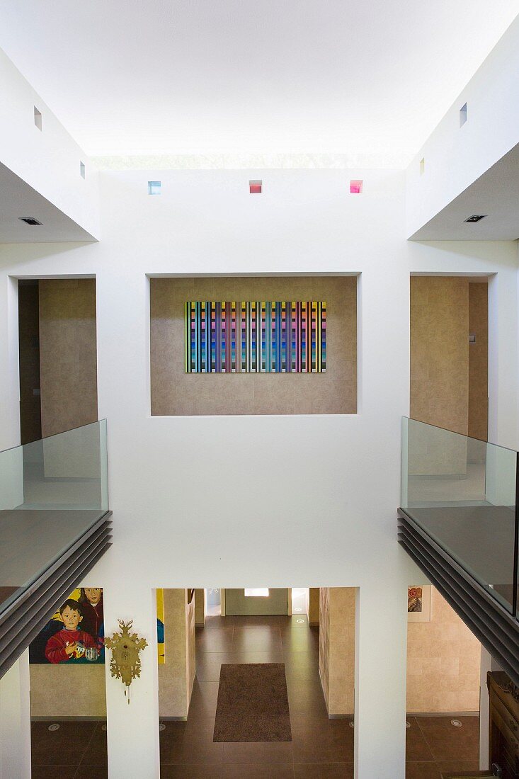 Blick von der Galerie mit Glasbrüstungen in den Eingangsbereich eines Architektenhauses