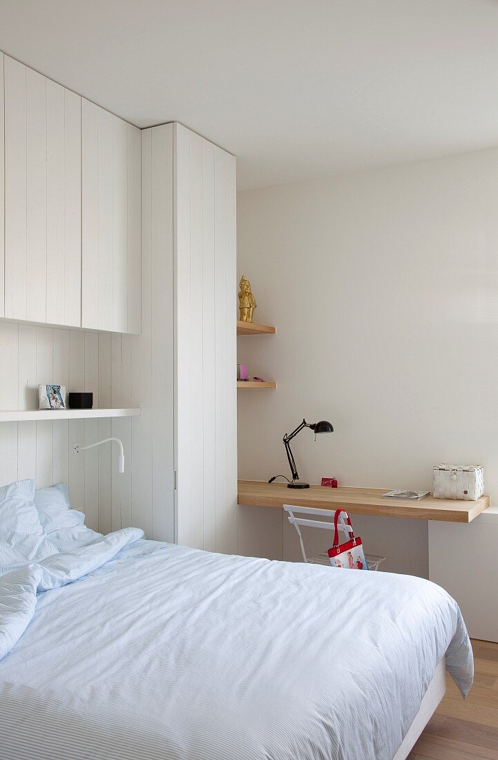 White, teenager's bedroom with custom fitted furnishings, bed and desk