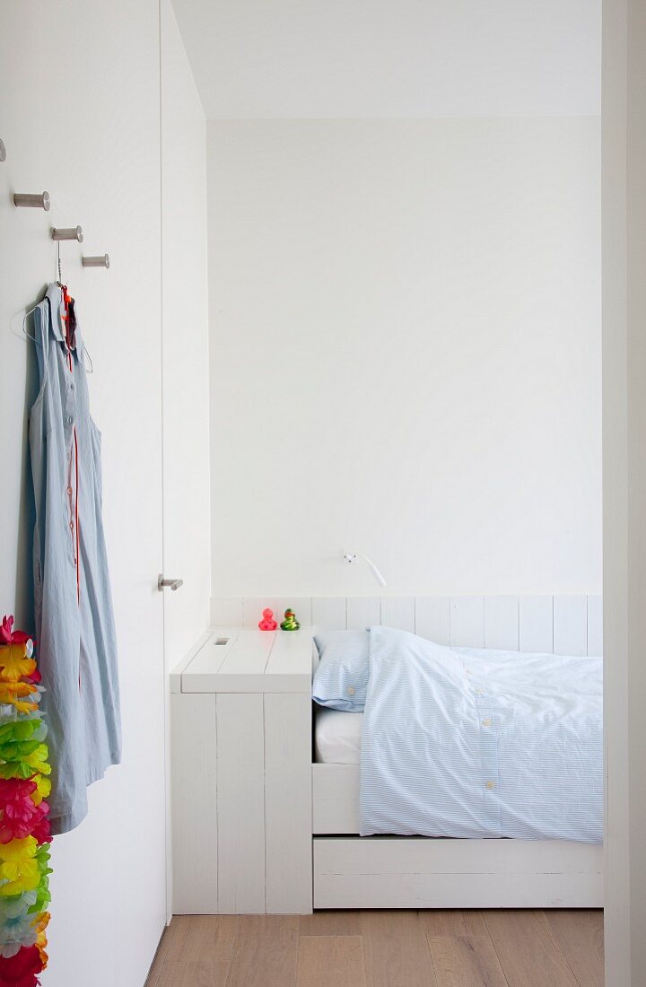 Weiß lackiertes Holzbett mit Schubladen und Bettkasten, Wandverkleidung und Einbauschrankwand