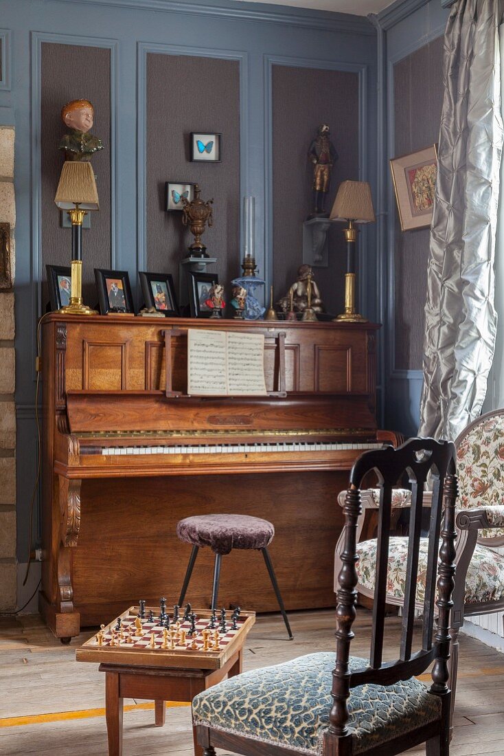 Piano against grey and blue wood panelling in elegant parlour