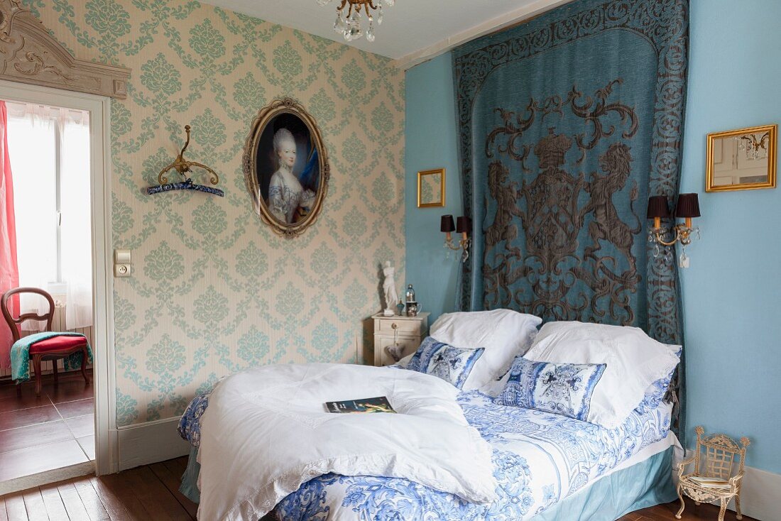 Elegantes, traditionelles Schlafzimmer mit Brokattapete, gerahmtem Frauengemälde und Wandbehang, französisches Flair