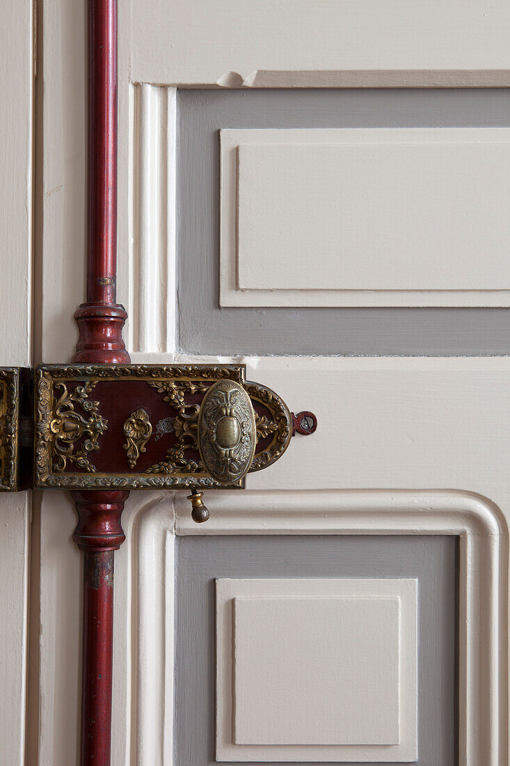 Ornate, antique metal lock on panelled interior door