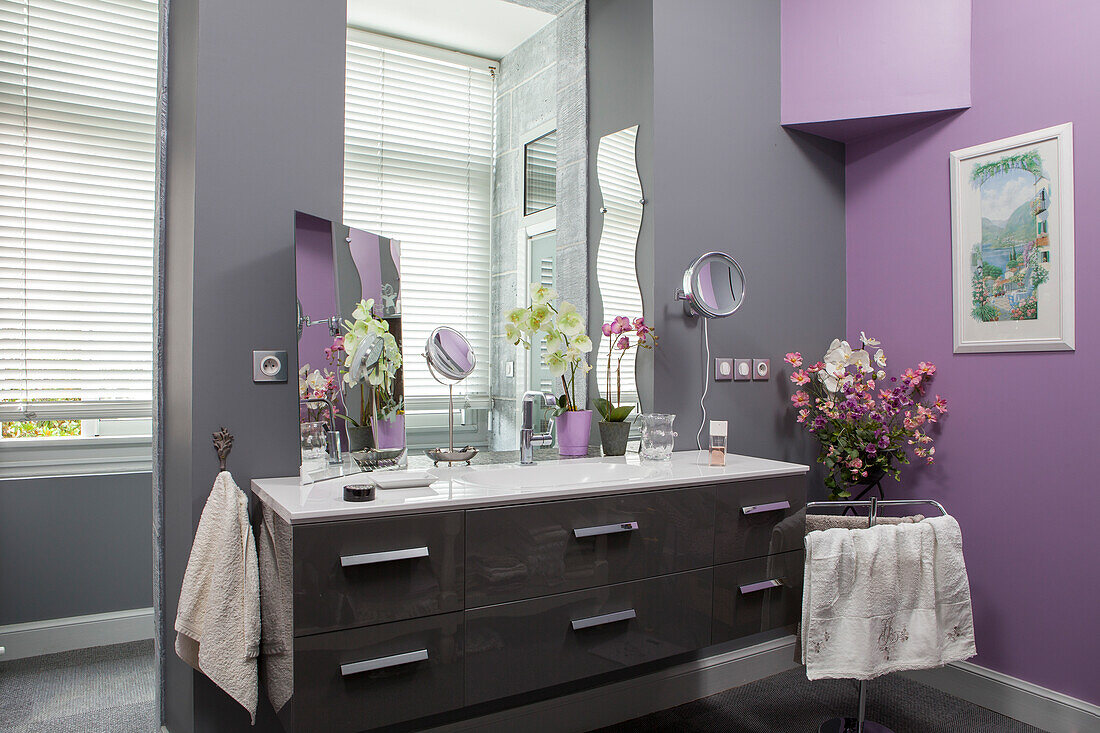 Modern washstand with base cabinet against walls painted grey and lilac