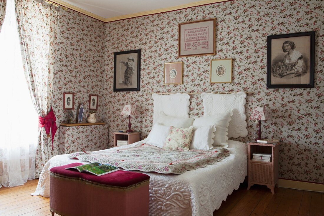 Traditionelles Schlafzimmer mit klassischer Tapete, Textilien mit Rosenmuster und antiken Möbeln