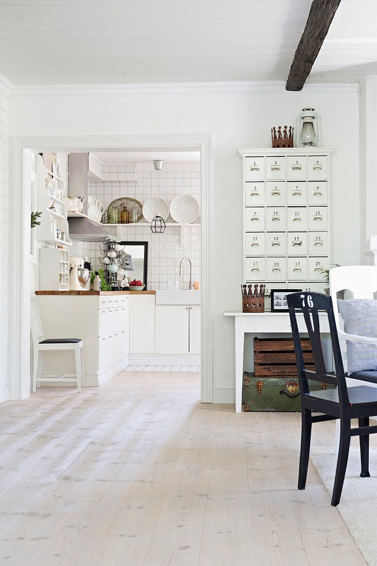 Blick von Esszimmer durch breiten Durchgang in Küche auf weiße Unterschränke