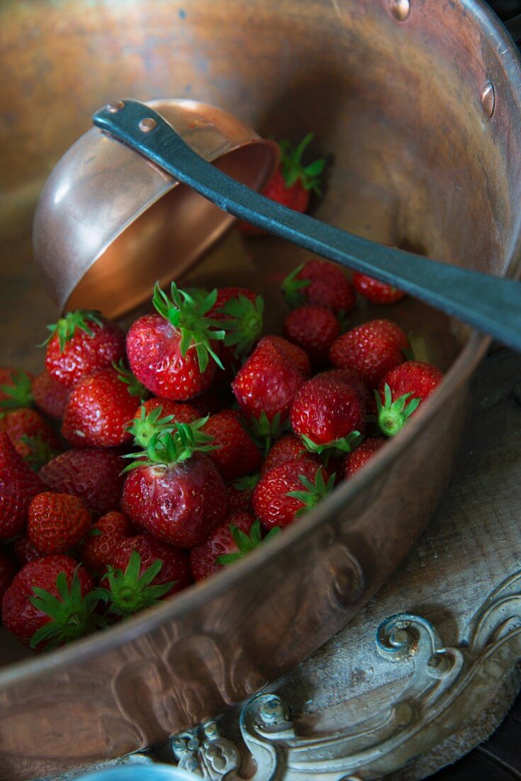 Frische Erdbeeren in Kupferschüssel mit Schöpfkelle