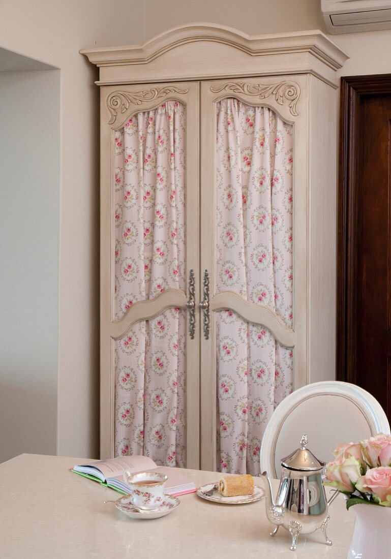 Old wardrobe with curtains behind glass doors