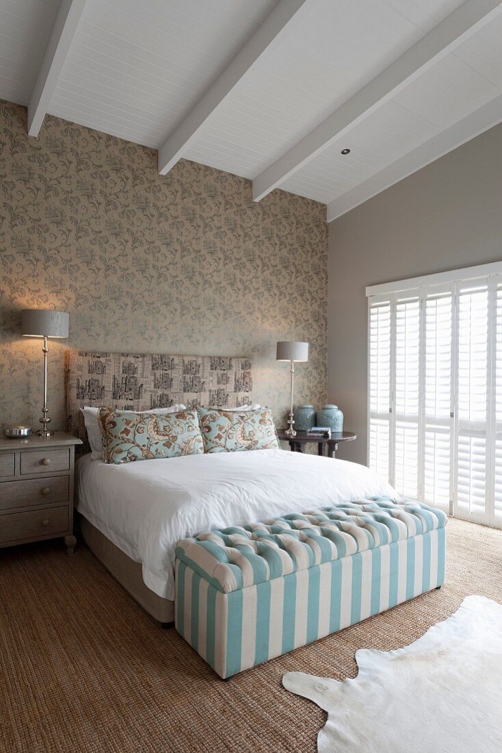 Elegantes Doppelbett in klassischem Schlafzimmer mit Sichtbalkendecke und gepolsterter Betttruhe