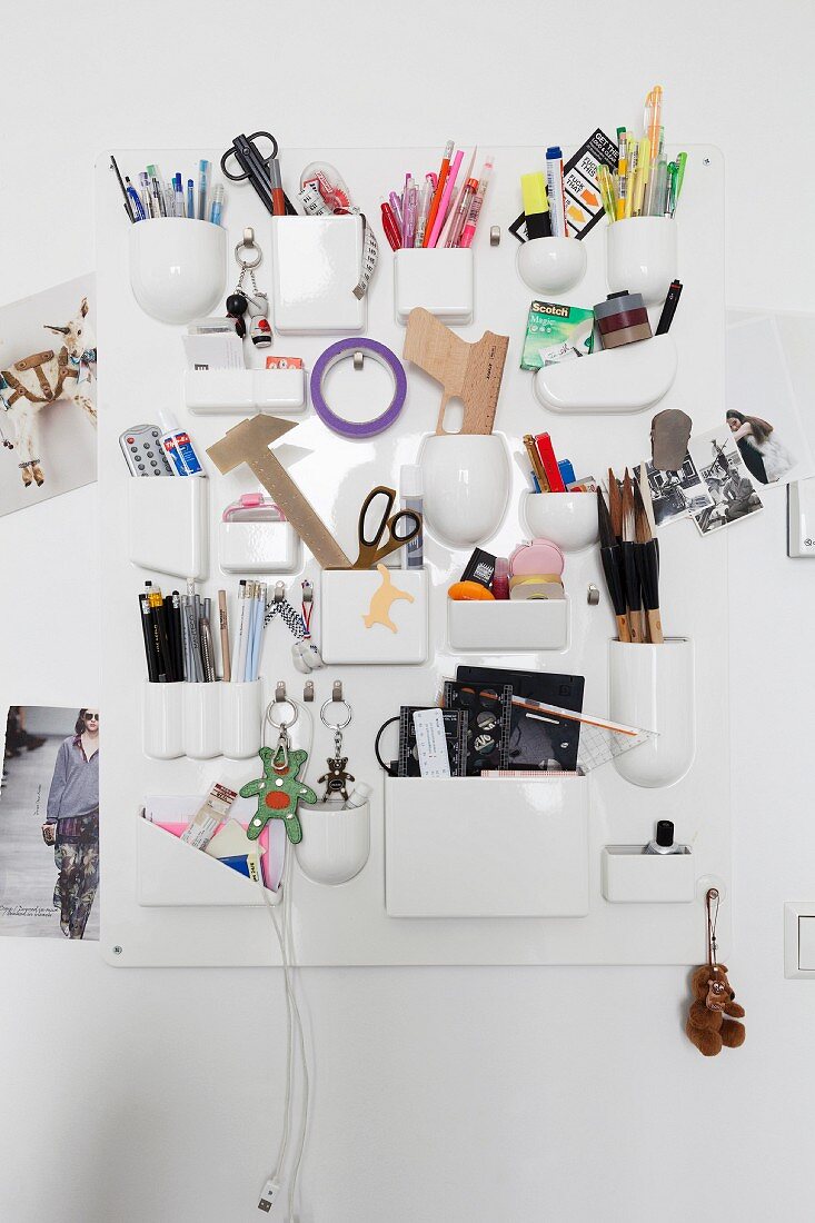 White organiser board with various pockets for storing drawing utensils and other objects