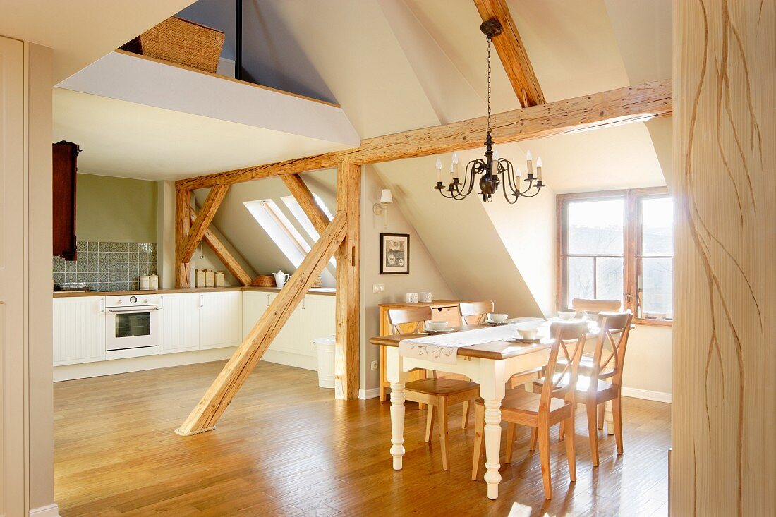 Offene Küche und Essplatz in ausgebautem Dachgeschoss mit rustikaler Holzbalkenkonstruktion