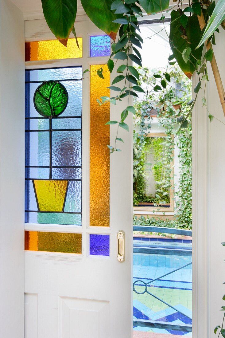 Geöffnete Schiebetür mit farbiger Glasfüllung, Blick auf Indoor-Pool