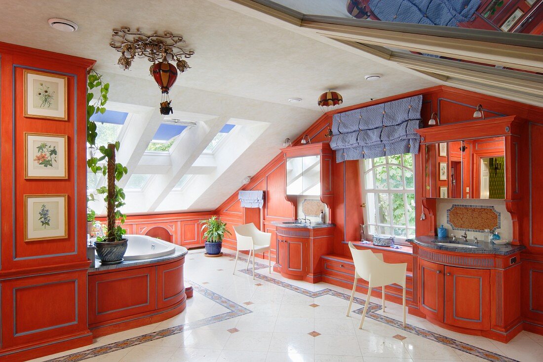 Luxuriöses Bad mit massgefertigten Schrankeinbauten rot lackiert und moderne Armlehnstühle im Dachraum
