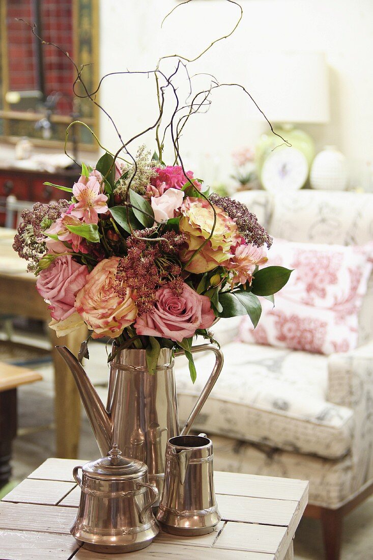 Blumenstrauss mit Weidenzweigen in eleganter Silberkanne, davor Zuckerdose und Milchkännchen aus Silber