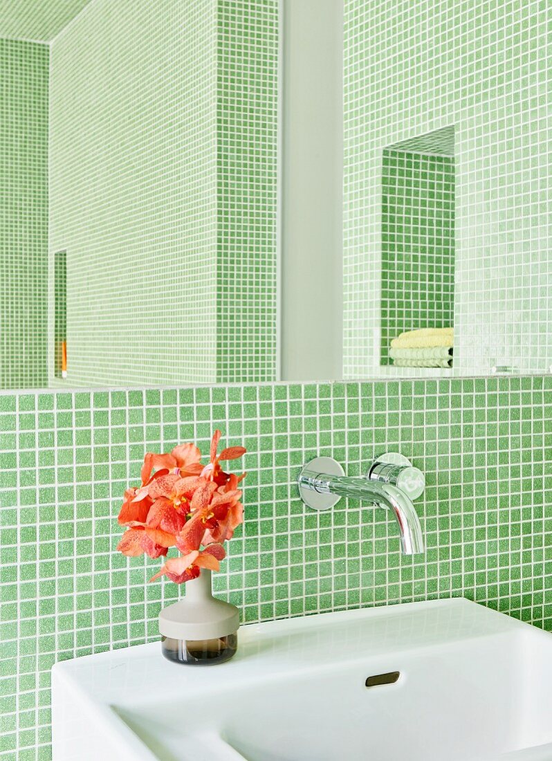 Badezimmer mit grünen Mosaikfliesen, Blumenstrauss auf Waschbecken