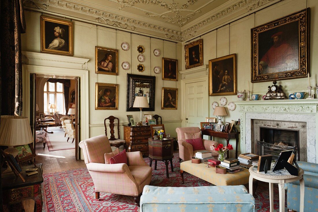 Oil portraits and antique furniture in living room of English manor house