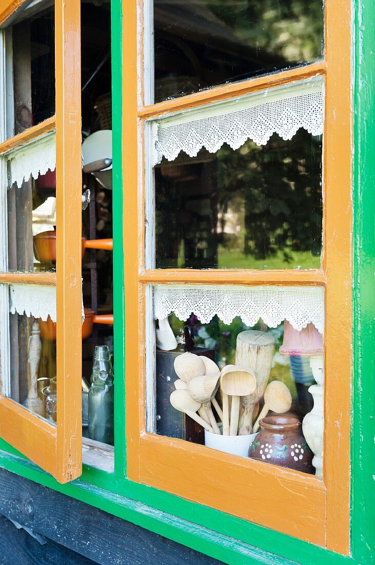 Blick durch bemaltes Sprossfenster auf Kochutensilien
