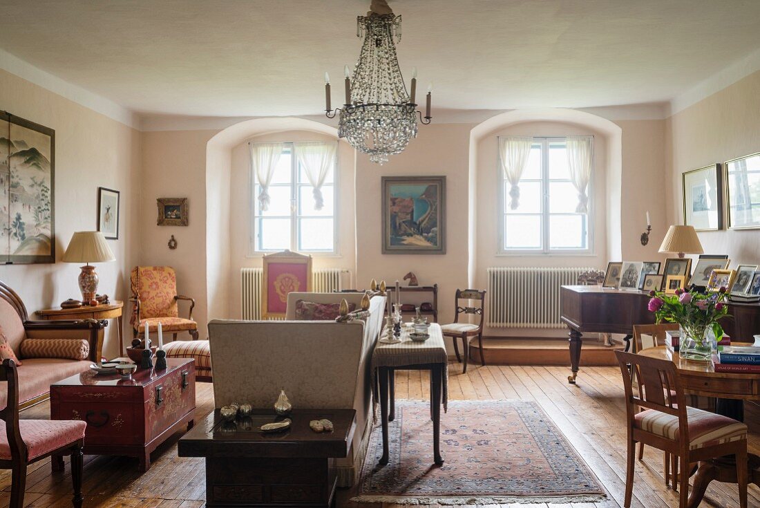 Grosszügige Wohnzimmer mit Stilmöbeln, Kronleuchter, im Hintergrund Fenster in Rundbogennischen