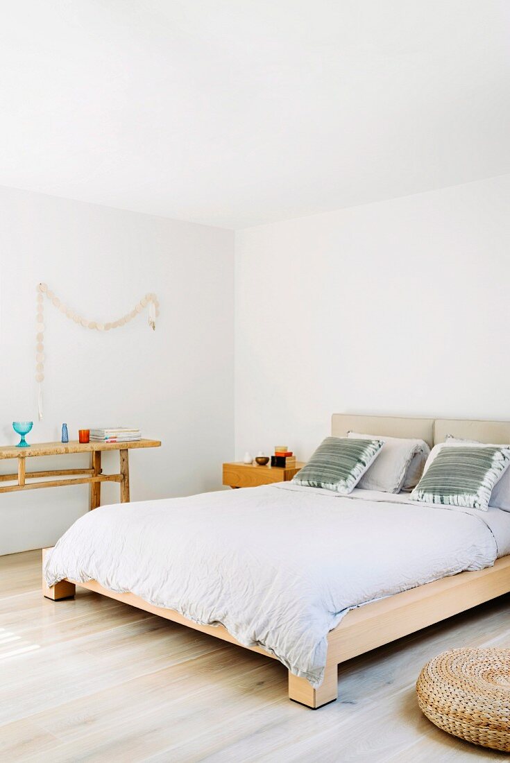 Puristisches Schlafzimmer mit hellen Holzmöbeln und weißen Wänden