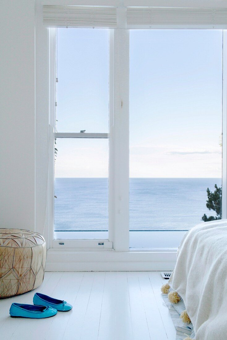 Helles Schlafzimmer mit Fenstertüren und Meerblick