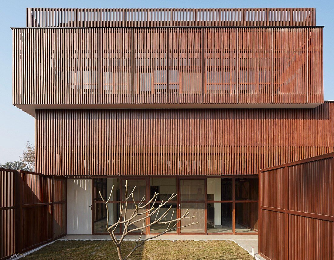 Facade of modern, Indian house with sunscreens and fences made from delicate wooden elements