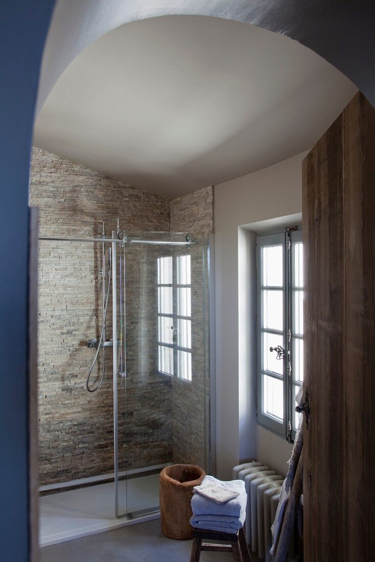 Shower with glass screen and stone wall tiles