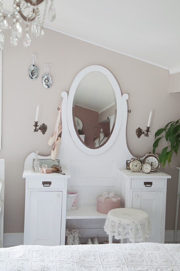 Weisser Schminktisch mit ovalem Spiegel an pastellgrau getönter Wand im Schlafzimmer