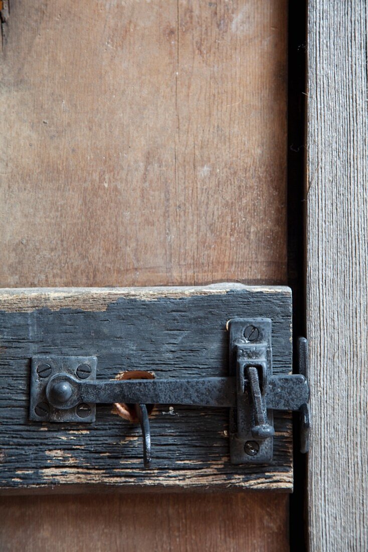 Wrought iron door latch on rustic wooden door
