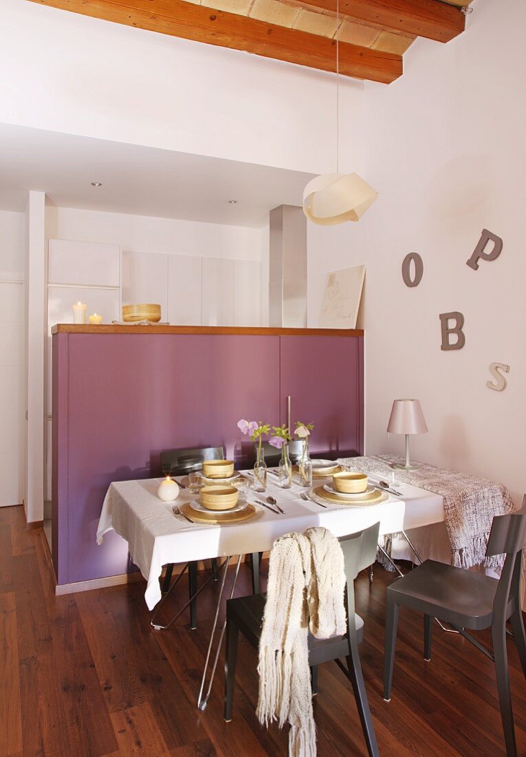 Set table in front of counter with lilac panel sides and decorative letters on wall