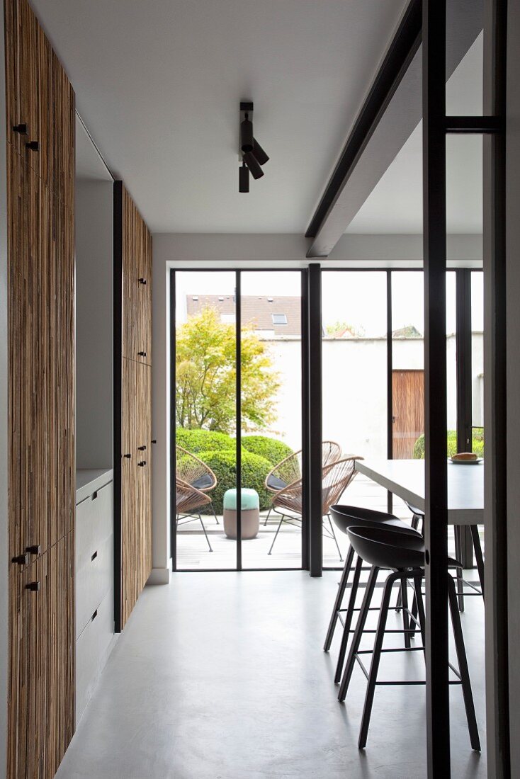 Open-plan kitchen with fitted cupboards, breakfast bar and French windows