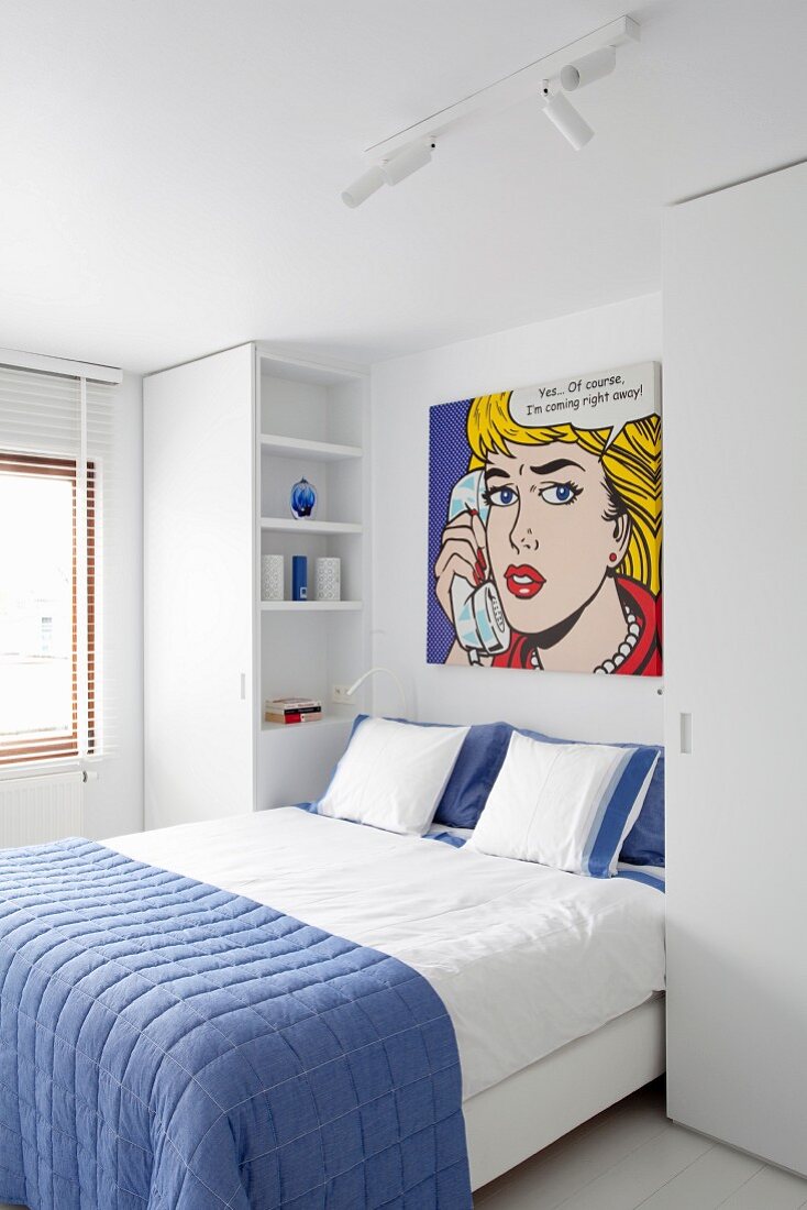 Double bed with blue bedspread below Pop-Art picture by Roy Lichtenstein in white modern bedroom