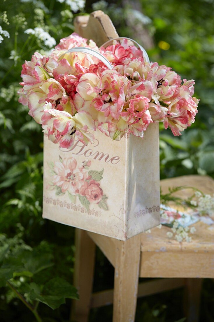 Aufgeblühte zweifarbige Tulpen in romantischer Tasche mit Blütenmotiv