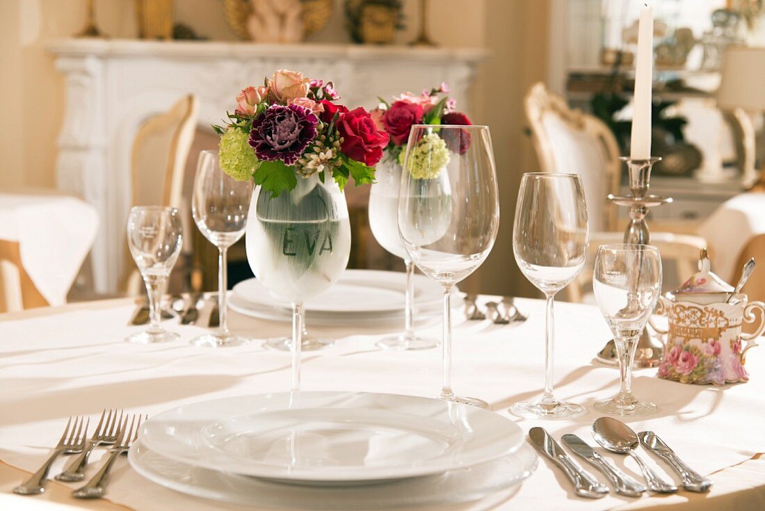 Festlich gedeckter Tisch mit Gedecken und Weingläsern, Blumenstrauss in Weinglas mit Namen