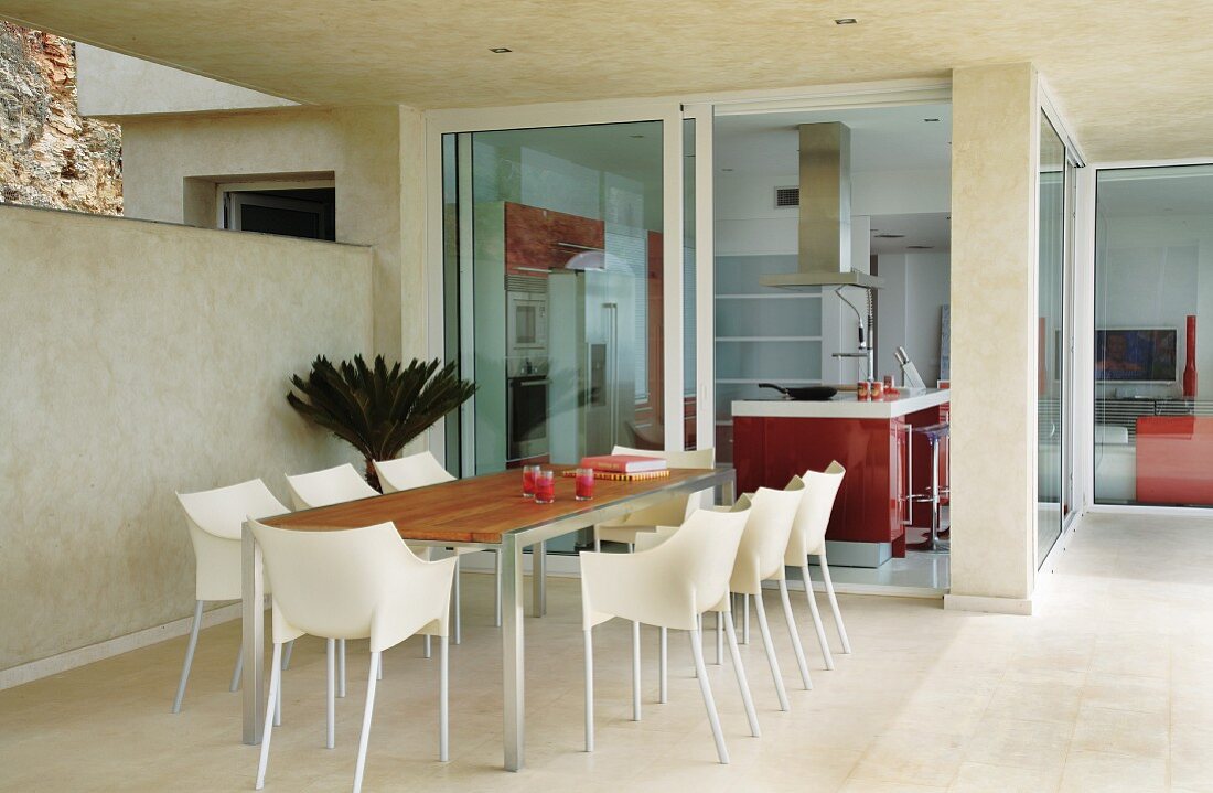 Dining set with plastic shell chairs on terrace of modern holiday home