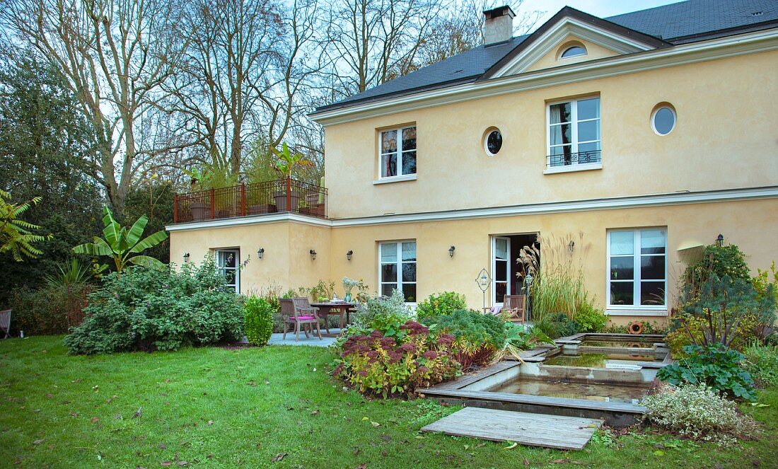 Französisches Landhaus, Gartenseite mit Terrasse und Wasserbecken